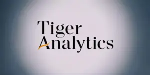 Tiger Analytics logo with black text and an orange swoosh under the 'A'.