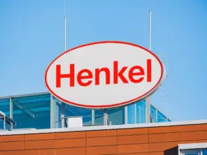 Henkel logo sign on a building against a clear blue sky.