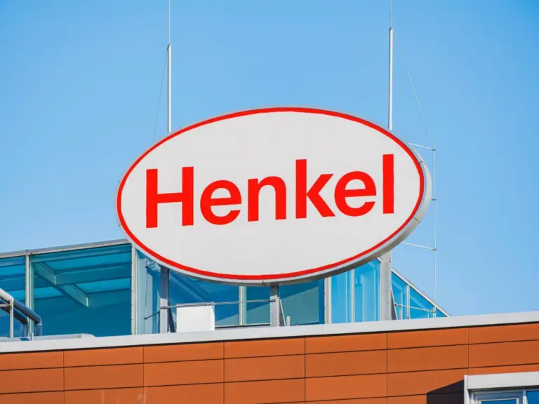 Henkel logo sign on a building against a clear blue sky.